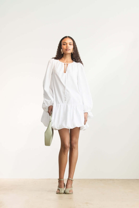 Model wearing a Lisemelo Bubble Hem Mini dress featuring long sleeves and a keyhole neckline.