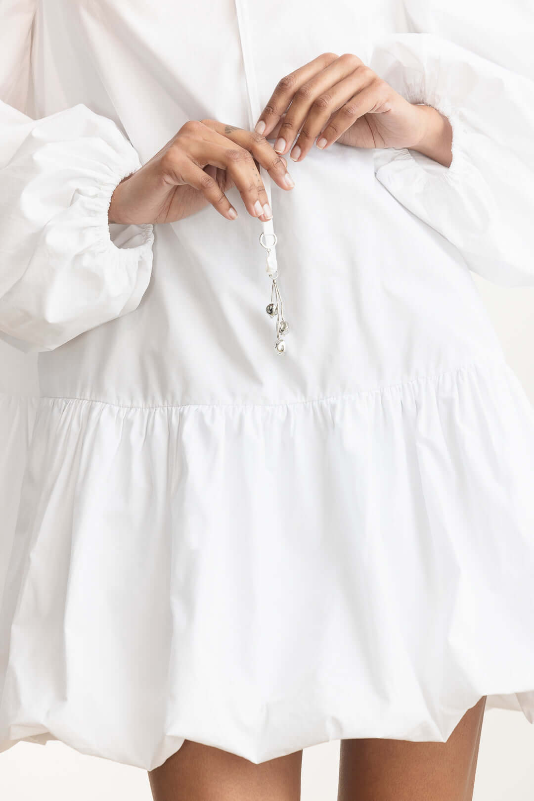 Lisemelo Bubble Hem Mini featuring a delicate tie neckline and voluminous long sleeves with a playful bubble hem.